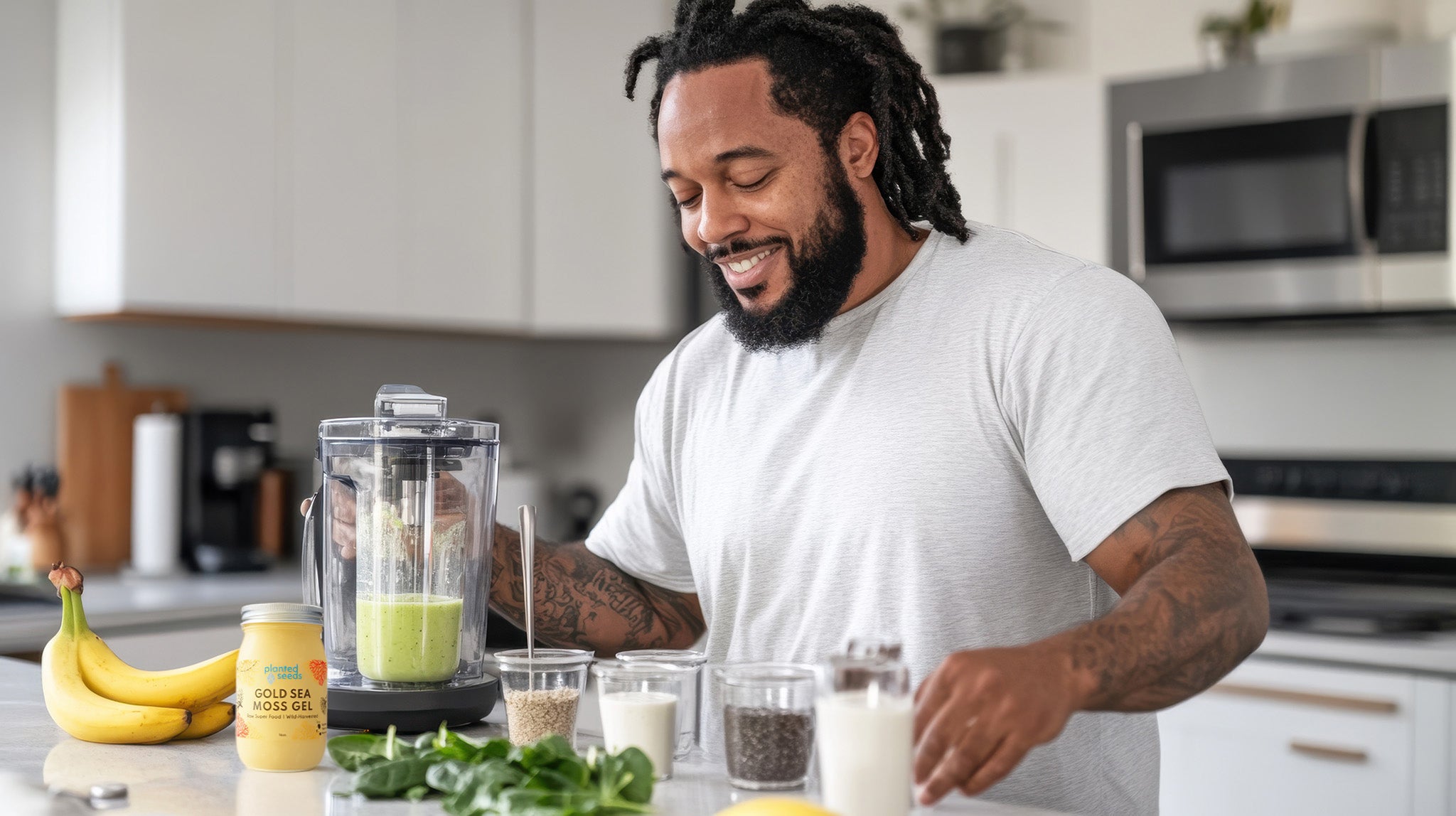Man making a smoothie in a kitchen with ingredients on the counter.