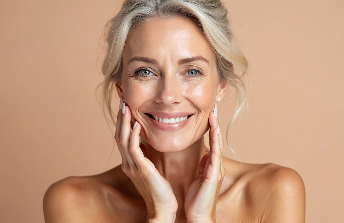 Woman with smooth skin touching her face against a beige background